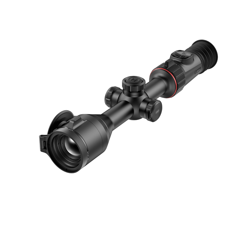 A black rifle scope with adjustment knobs and a red accent ring, shown at an angle.