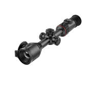 A black rifle scope with adjustment knobs and a red accent ring, shown at an angle.