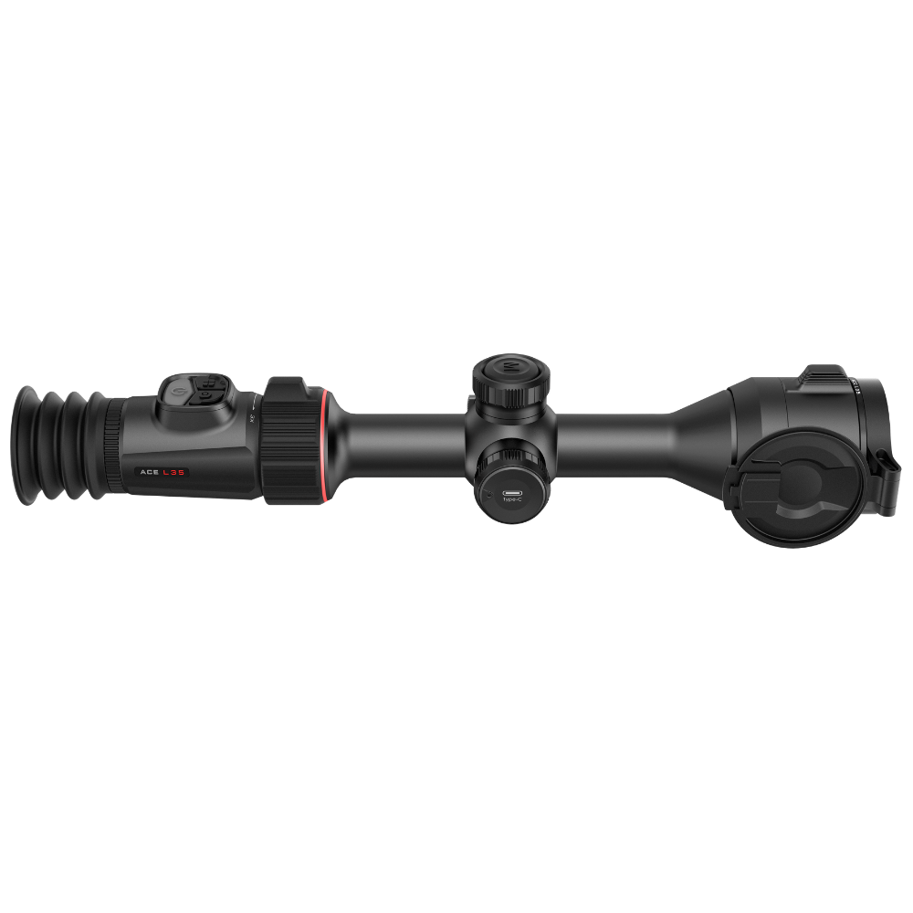 A black rifle scope with a hinged flip-up cover, shown from the side.